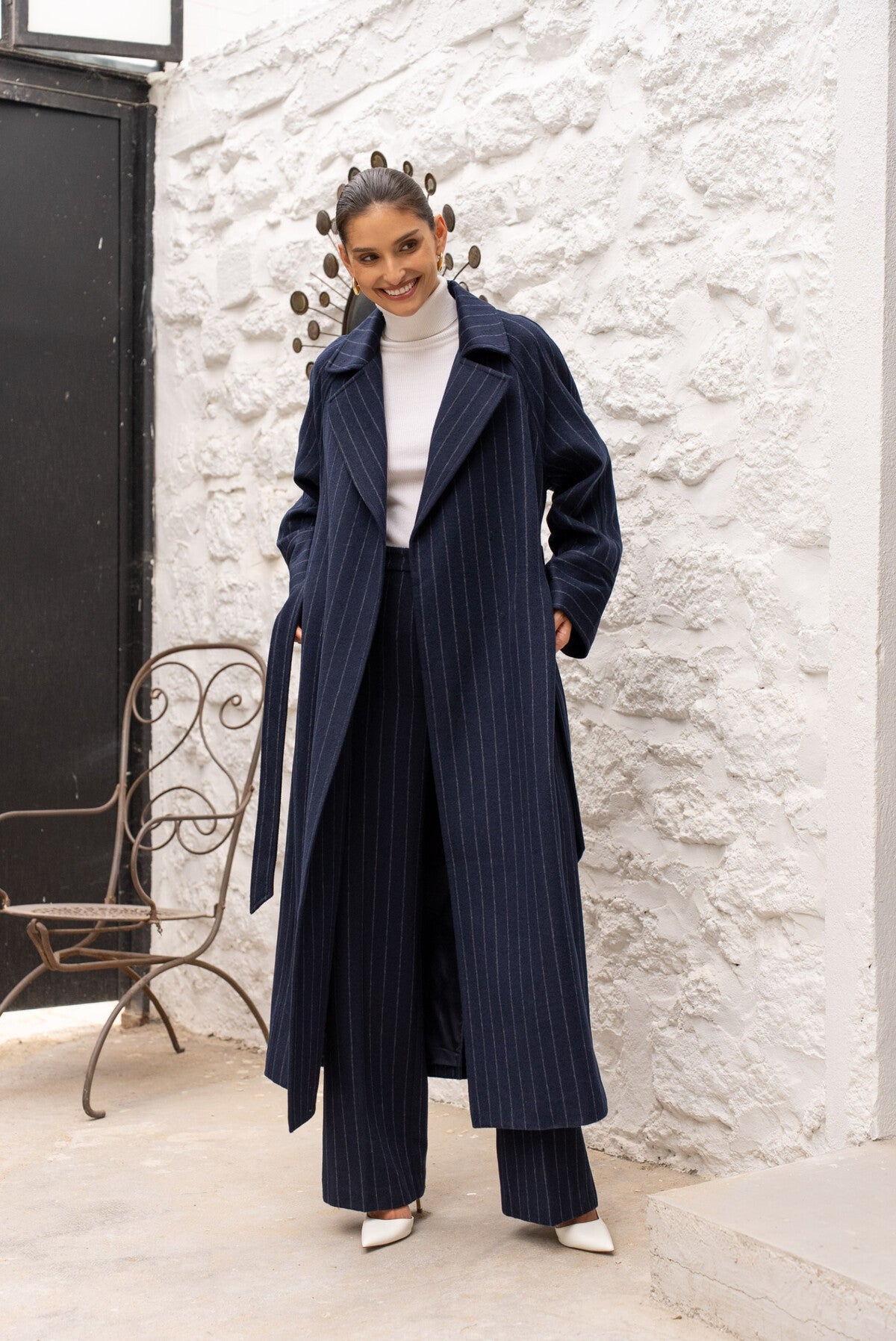 Close-up of pinstripe fabric and tie belt on Amelia navy coat.