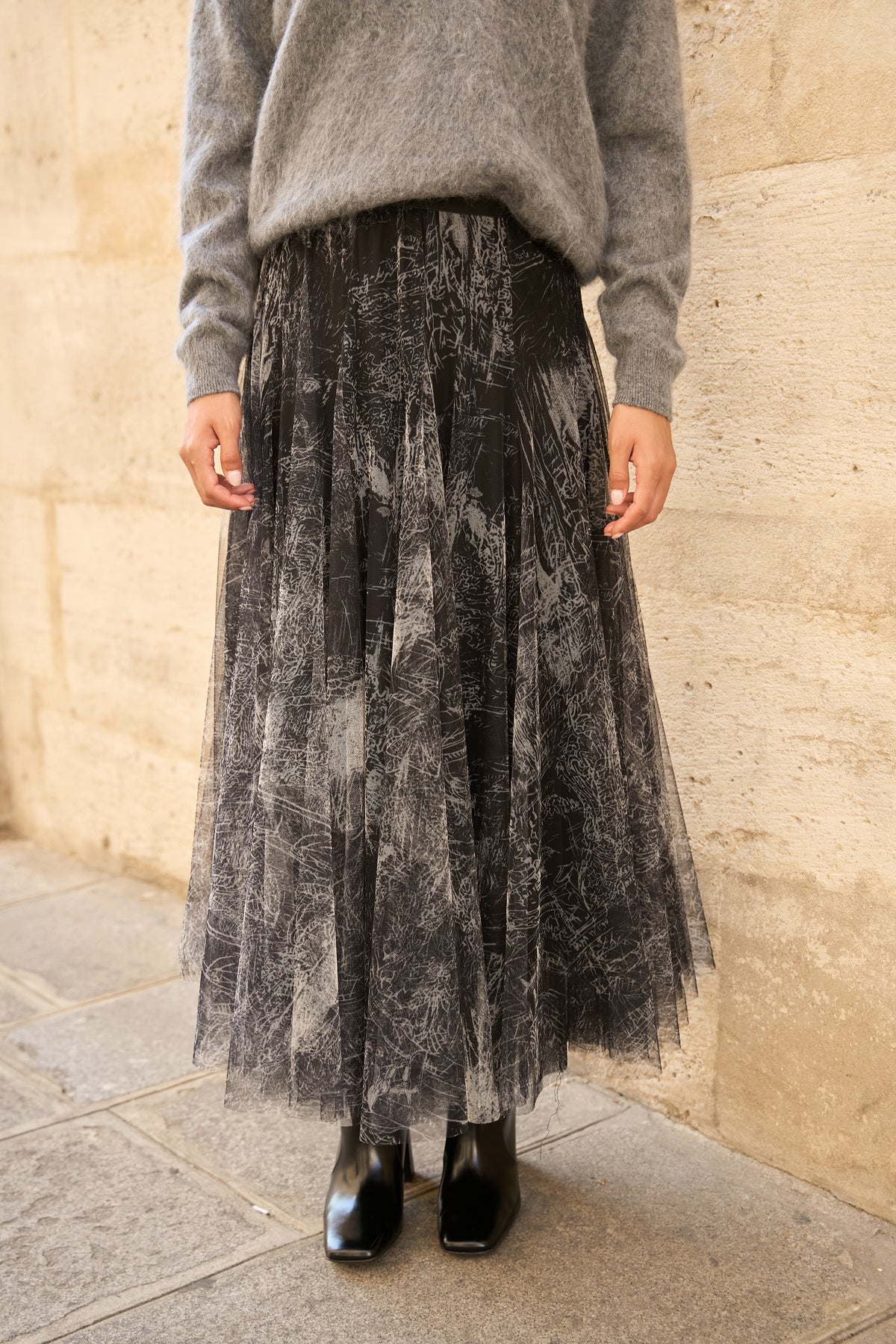 Black printed tulle midi skirt with layered A-line silhouette and fitted waistband