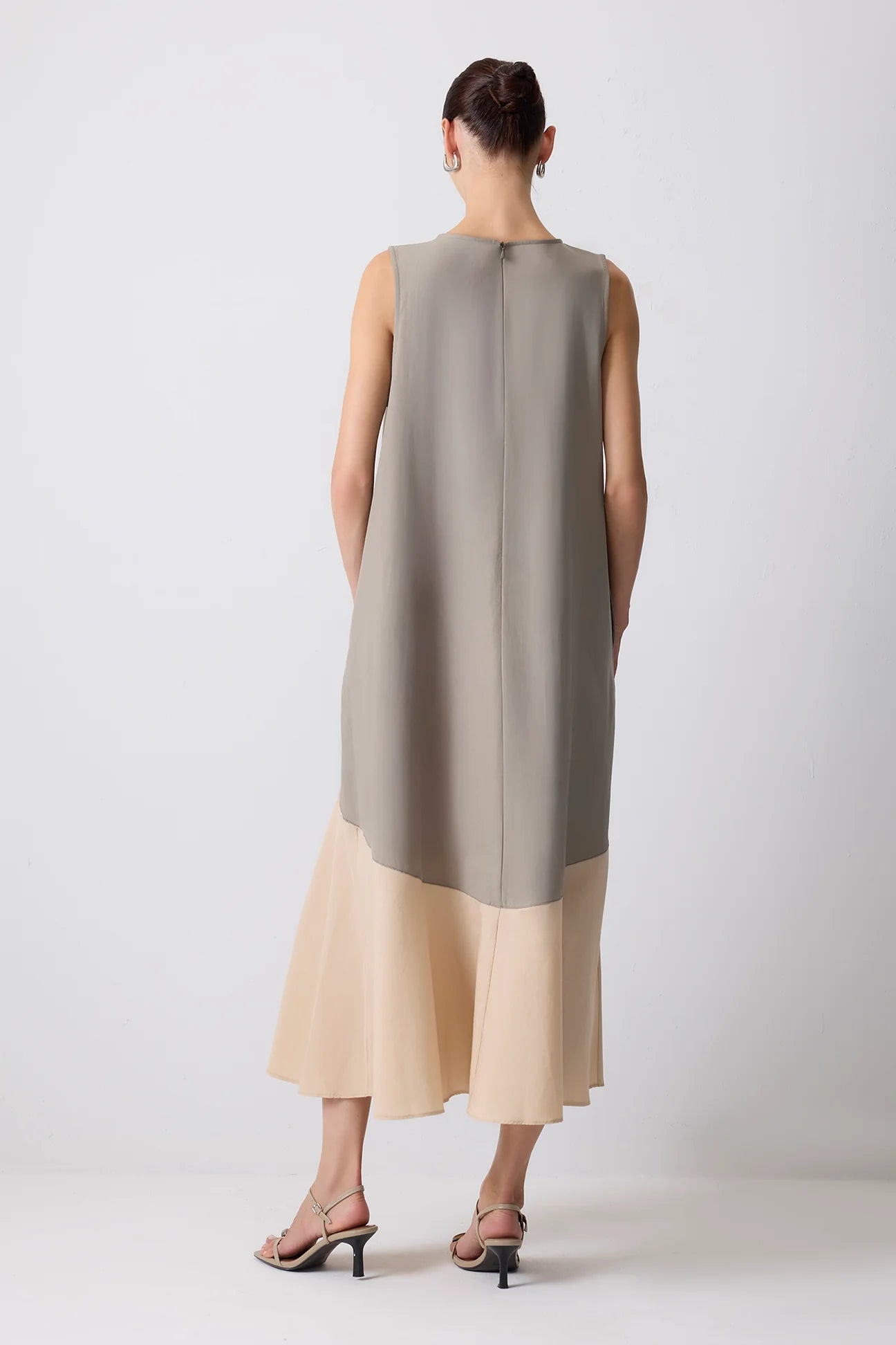 Full-length back shot of colour block poplin midi dress styled with heels.