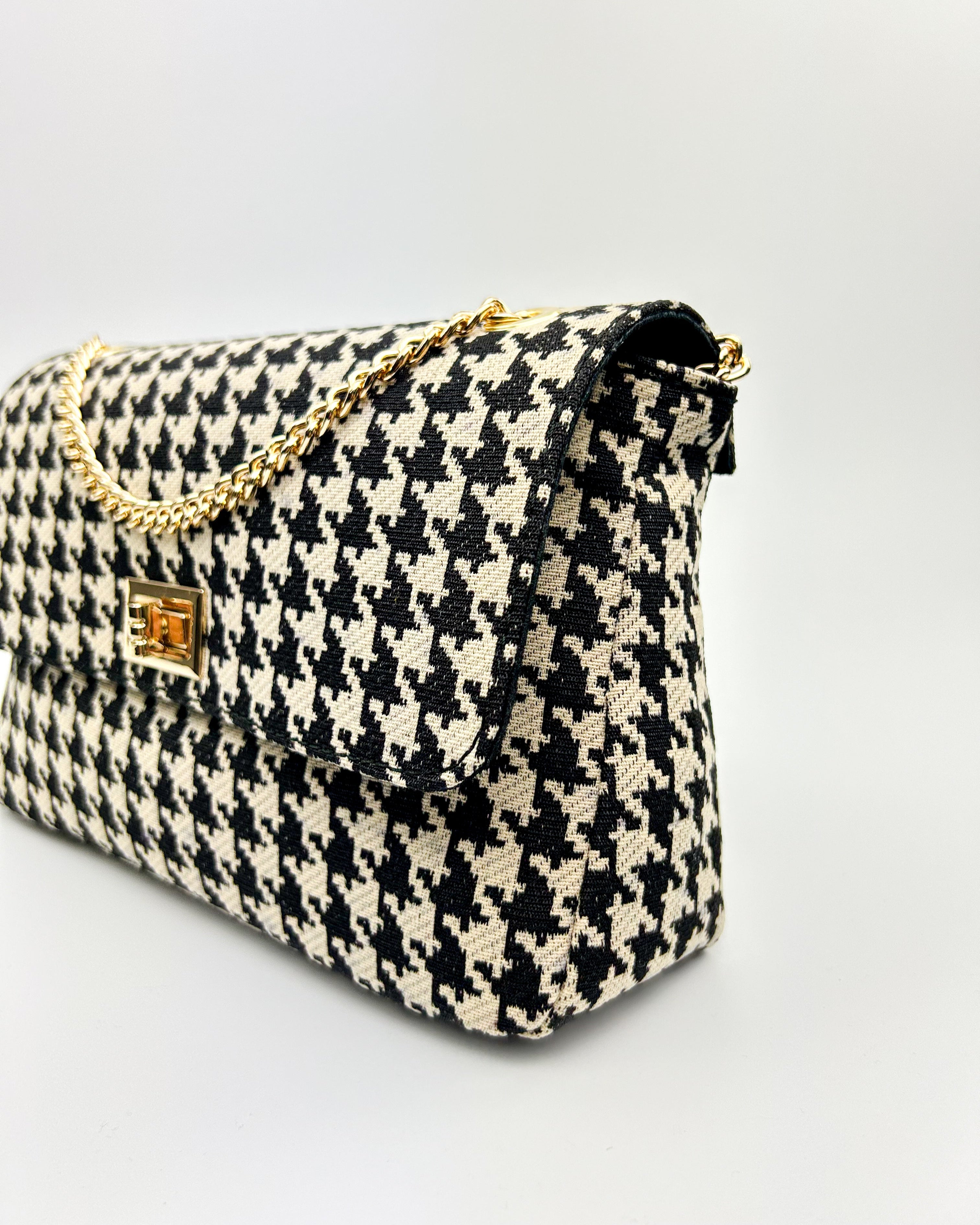 side view of black and white Emma bag crossbody with gold strap