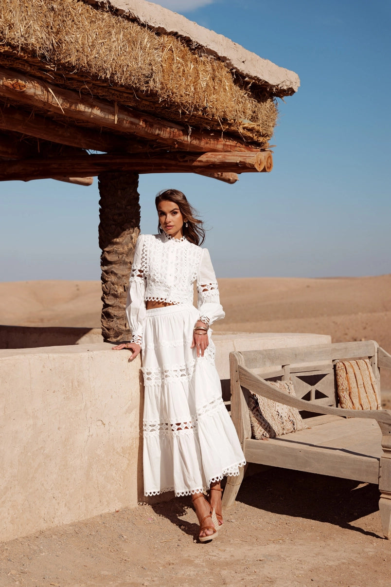 2-piece white outfit with long sleeve crop top and tiered skirt
