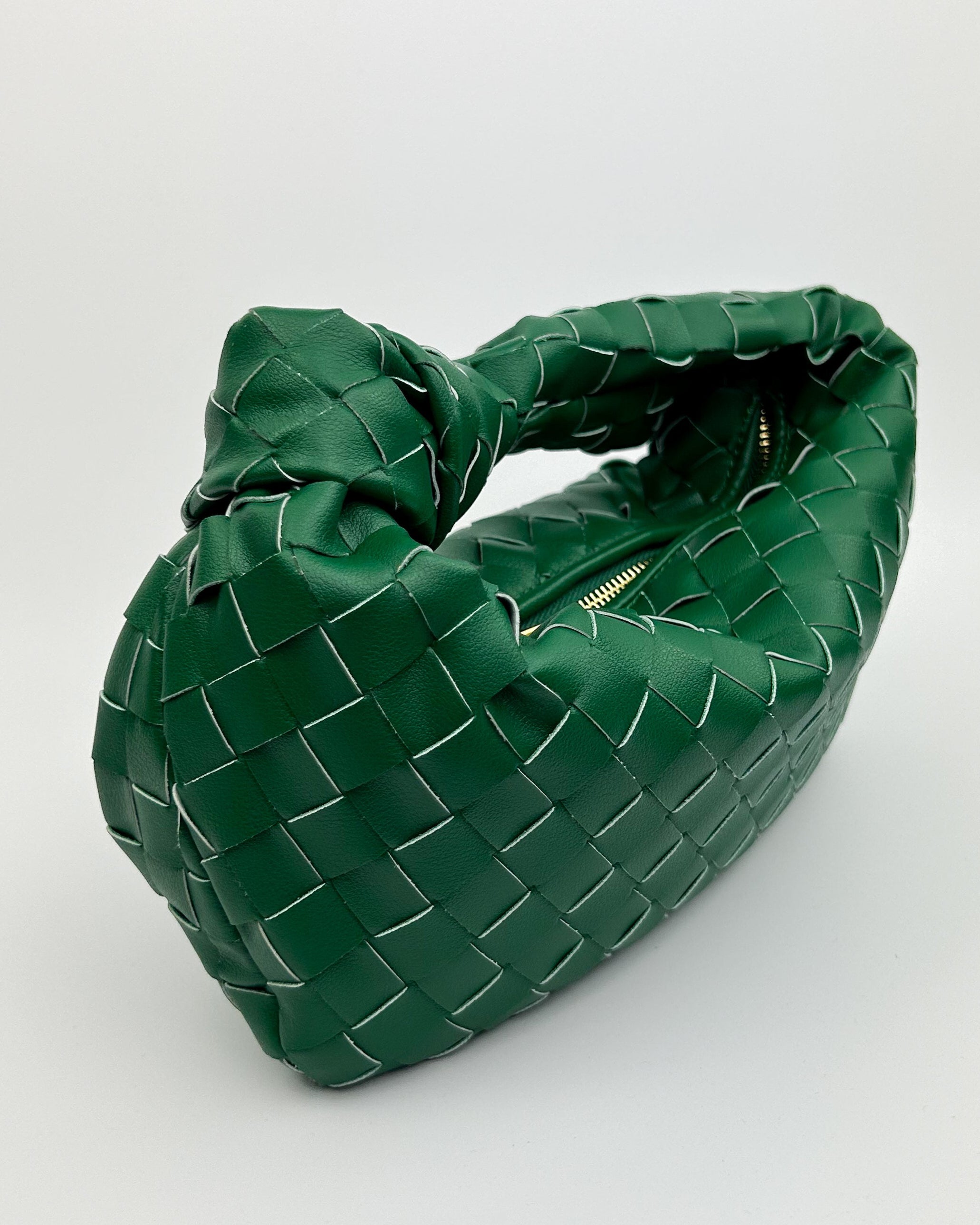 Close-up of premium woven calf leather texture and hand-knotted handle on The Knot Bag in green