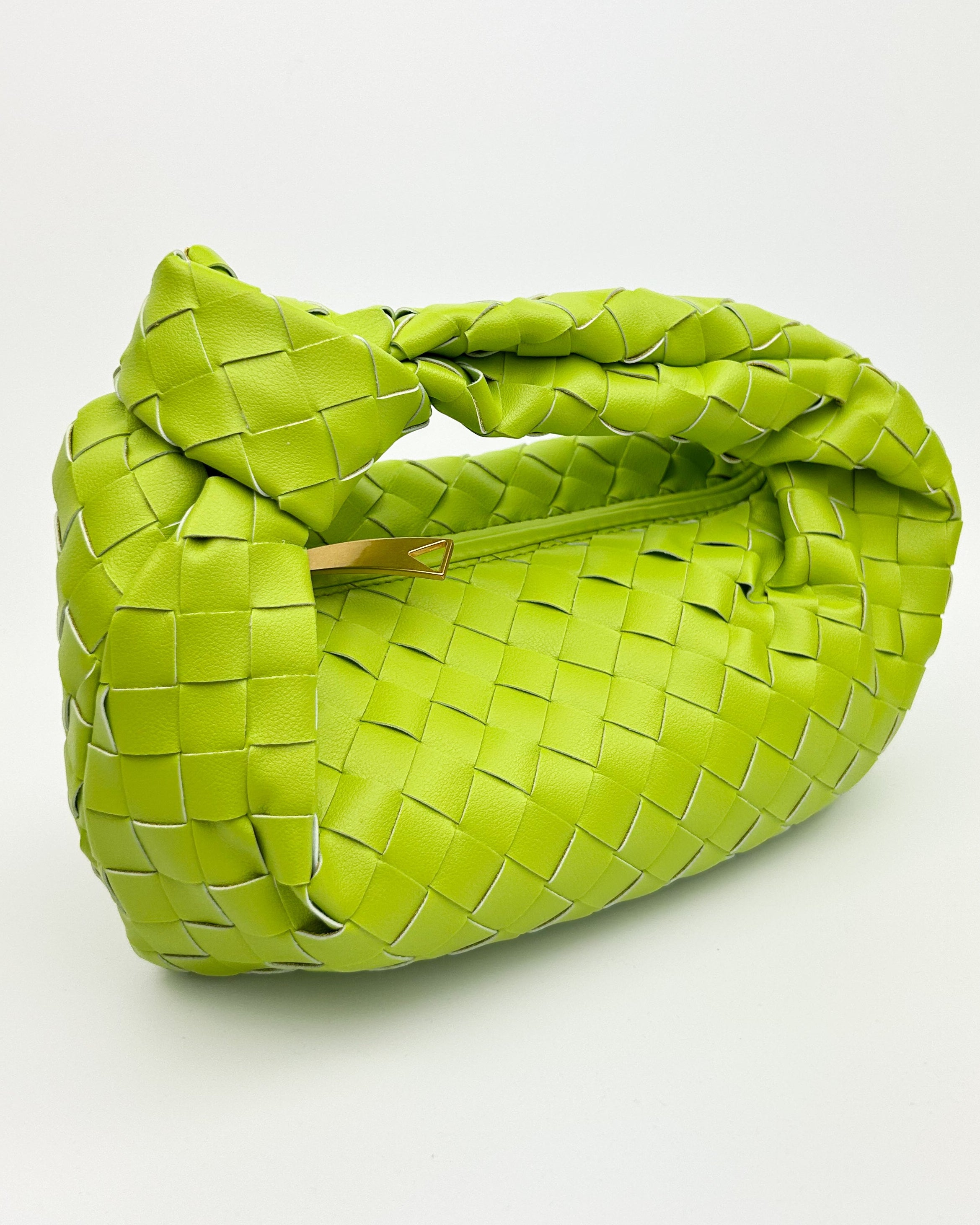 Close-up of woven lime green calf leather and signature knot handle – luxury handcrafted green leather bag