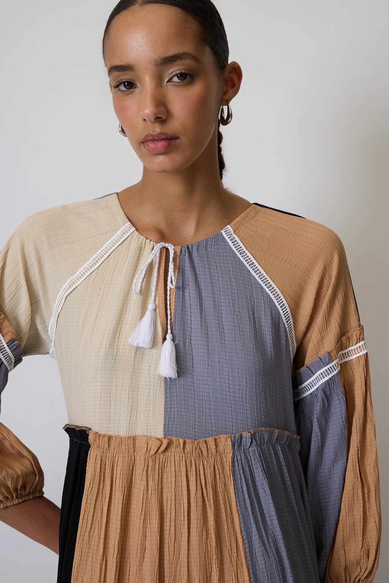 Close‑up of multi‑panel colour block fabric detail on tiered dress