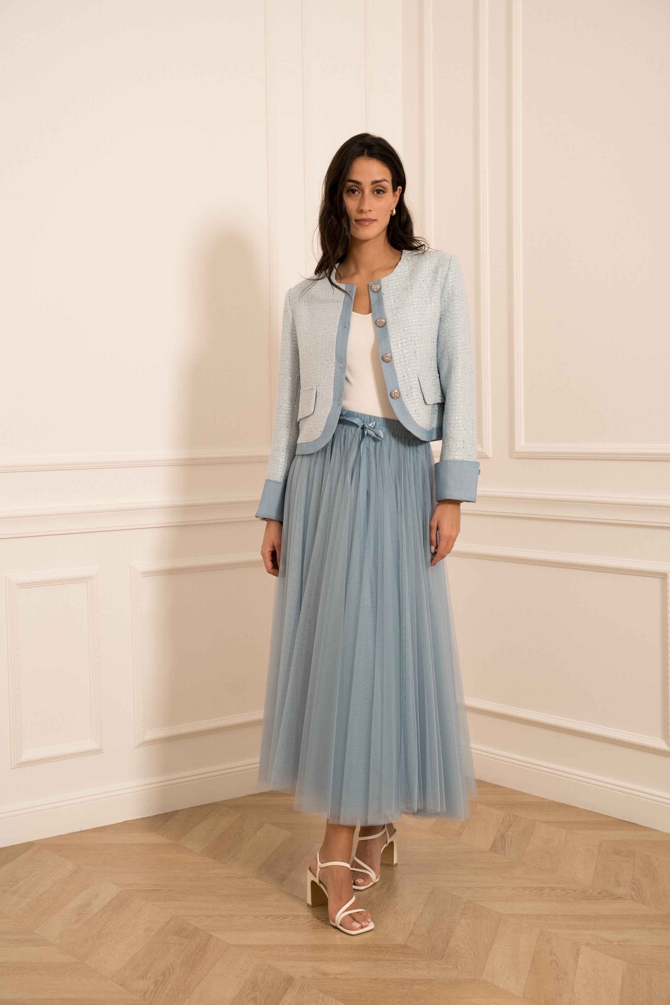 Sky blue bouclé blazer detail showing textured tweed fabric and round neckline.