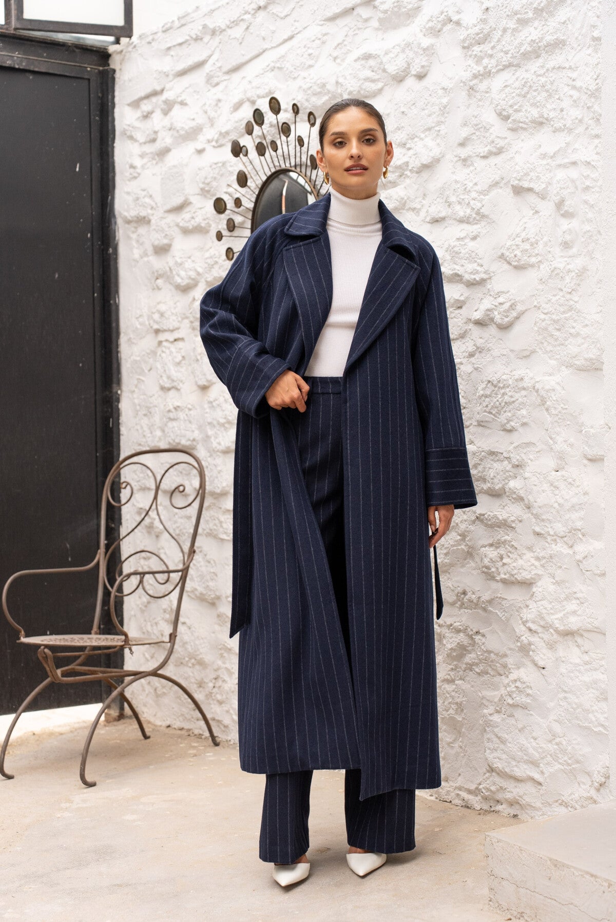 Front view of navy wool-blend long coat showing lapel collar and side pockets.