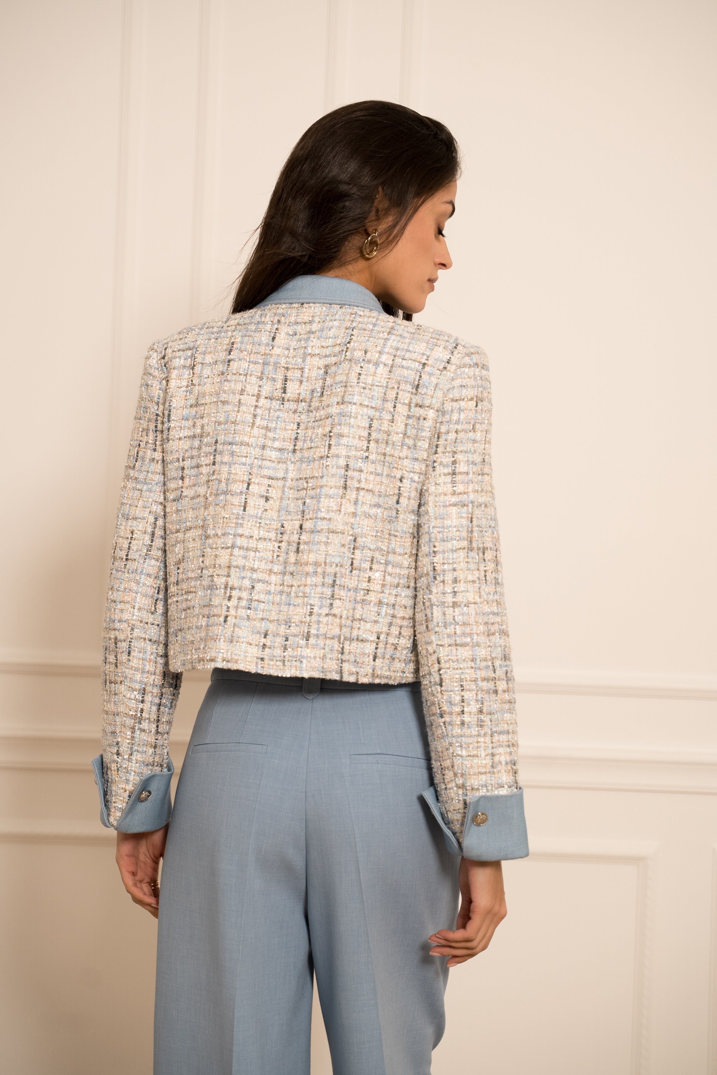 Cream tweed jacket detail showing textured bouclé fabric and blue collar