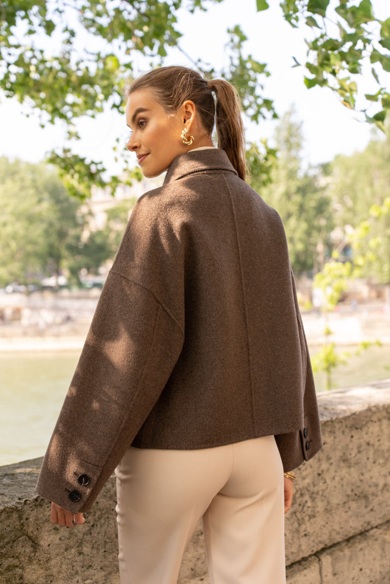 Back view of women’s short wool coat with loose structured fit