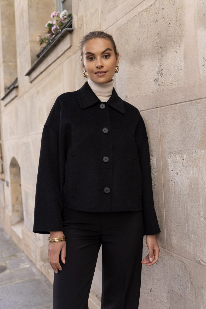 Front view of women’s short wool coat in black – hand-sewn wool blend with buttons.