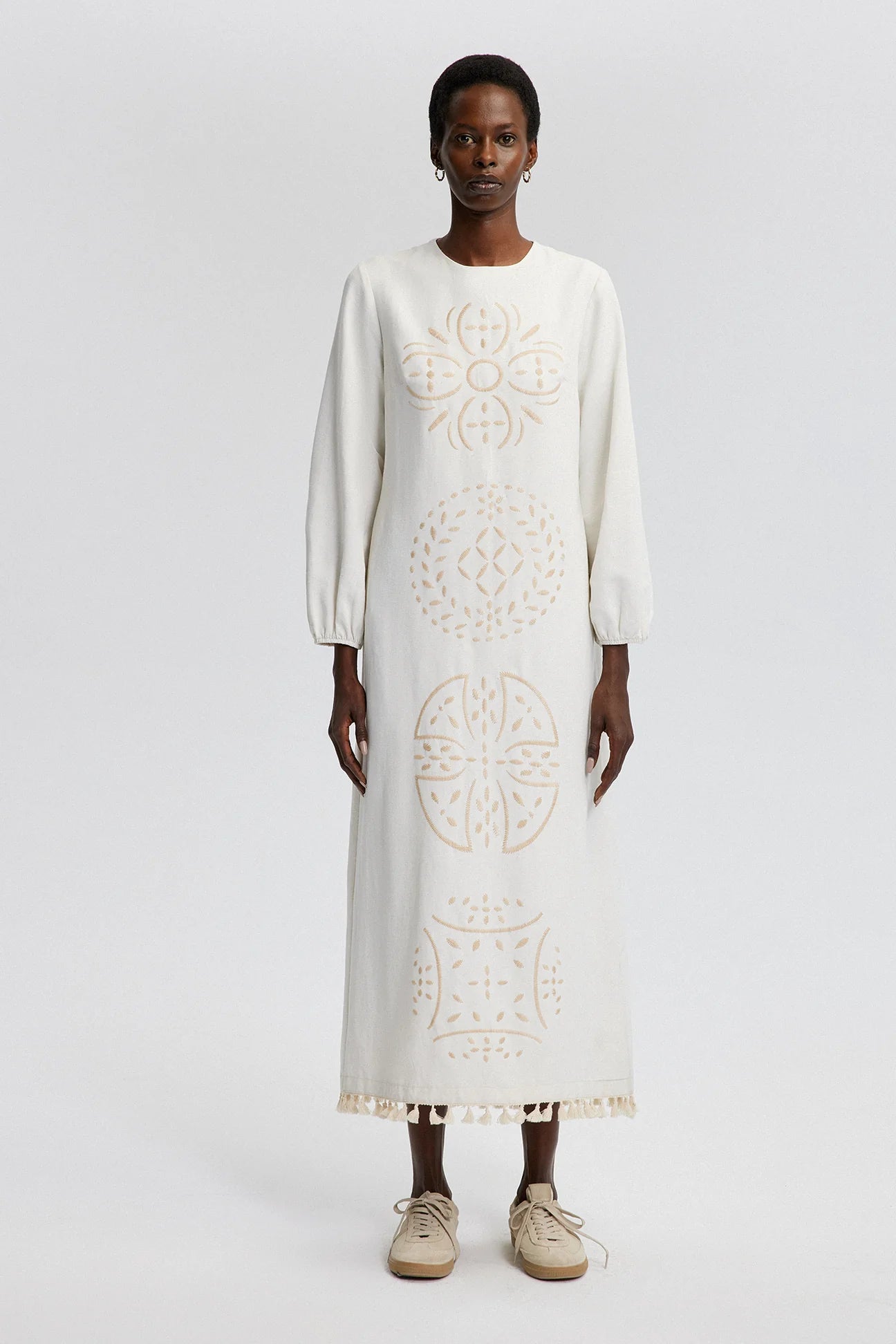 view of ankle-length beige folk embroidery dress with tassel hem