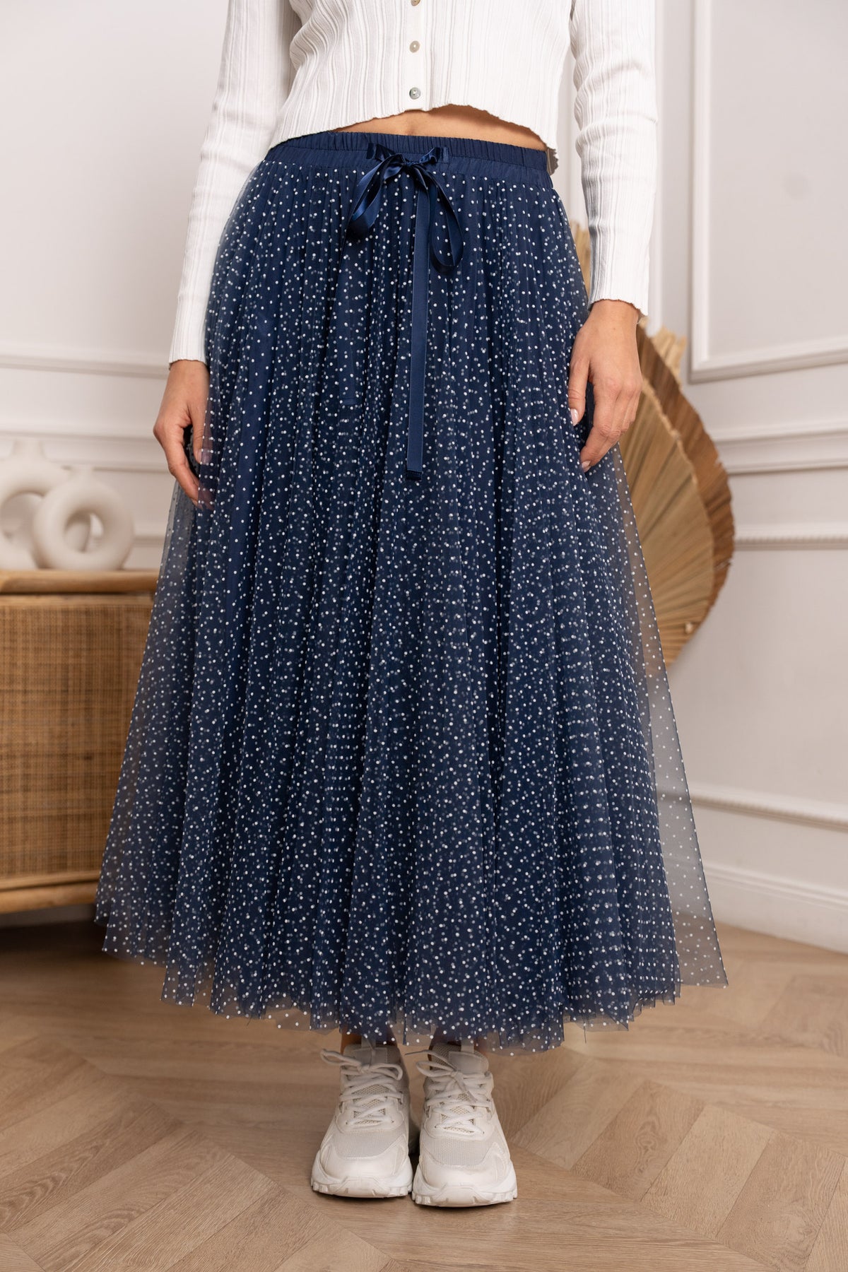 Close-up of navy tulle skirt with white polka dots, elasticated waistband and satin tie