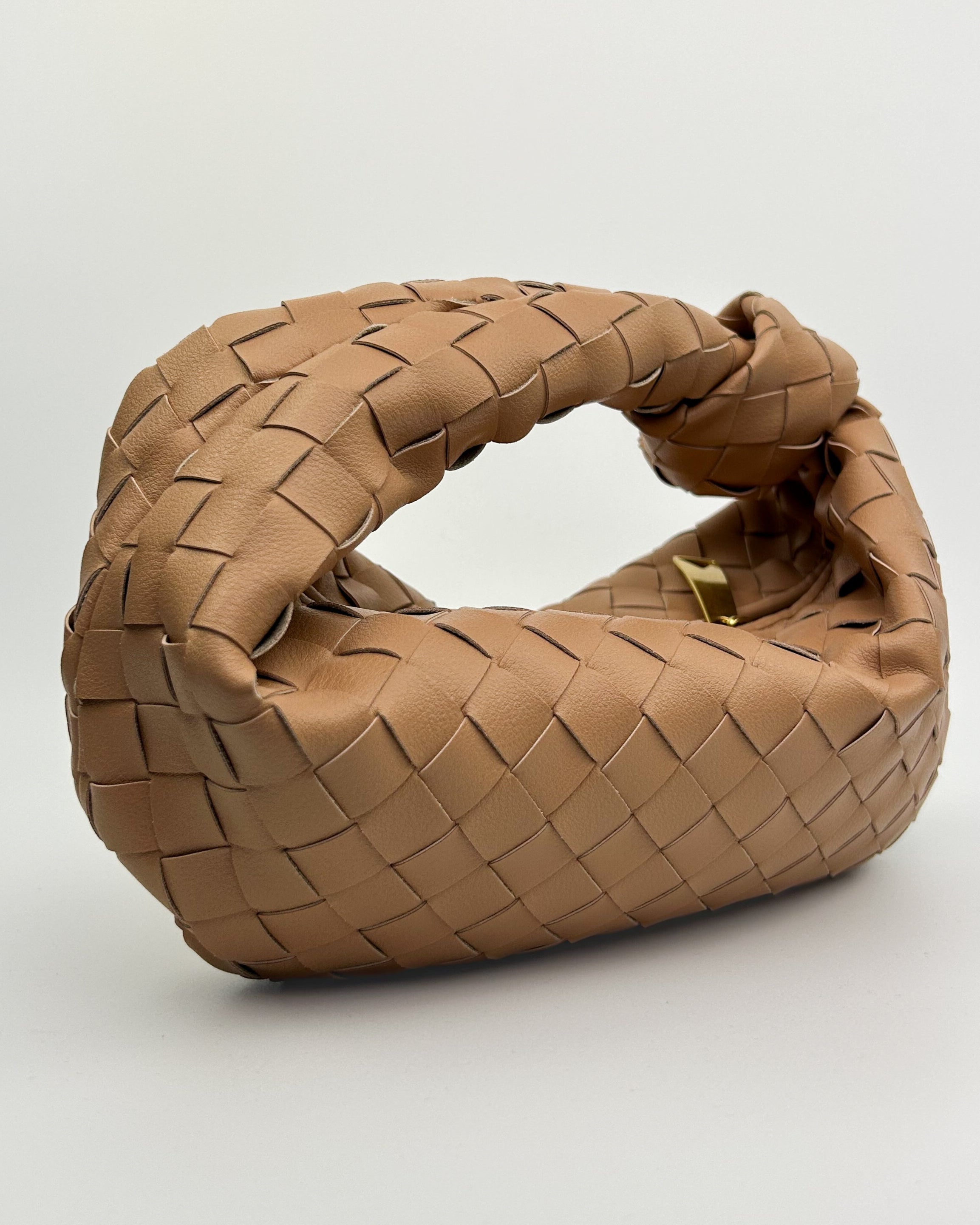 Close-up of genuine calf leather woven texture and artisanal knotted handle – handcrafted Italian top handle bag