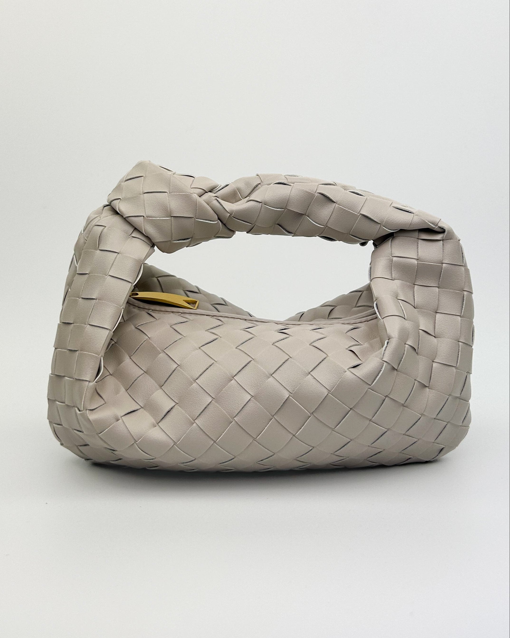Front view of The Knot Woven Bag in oyster white, Italian calf leather with crescent shape and woven finish