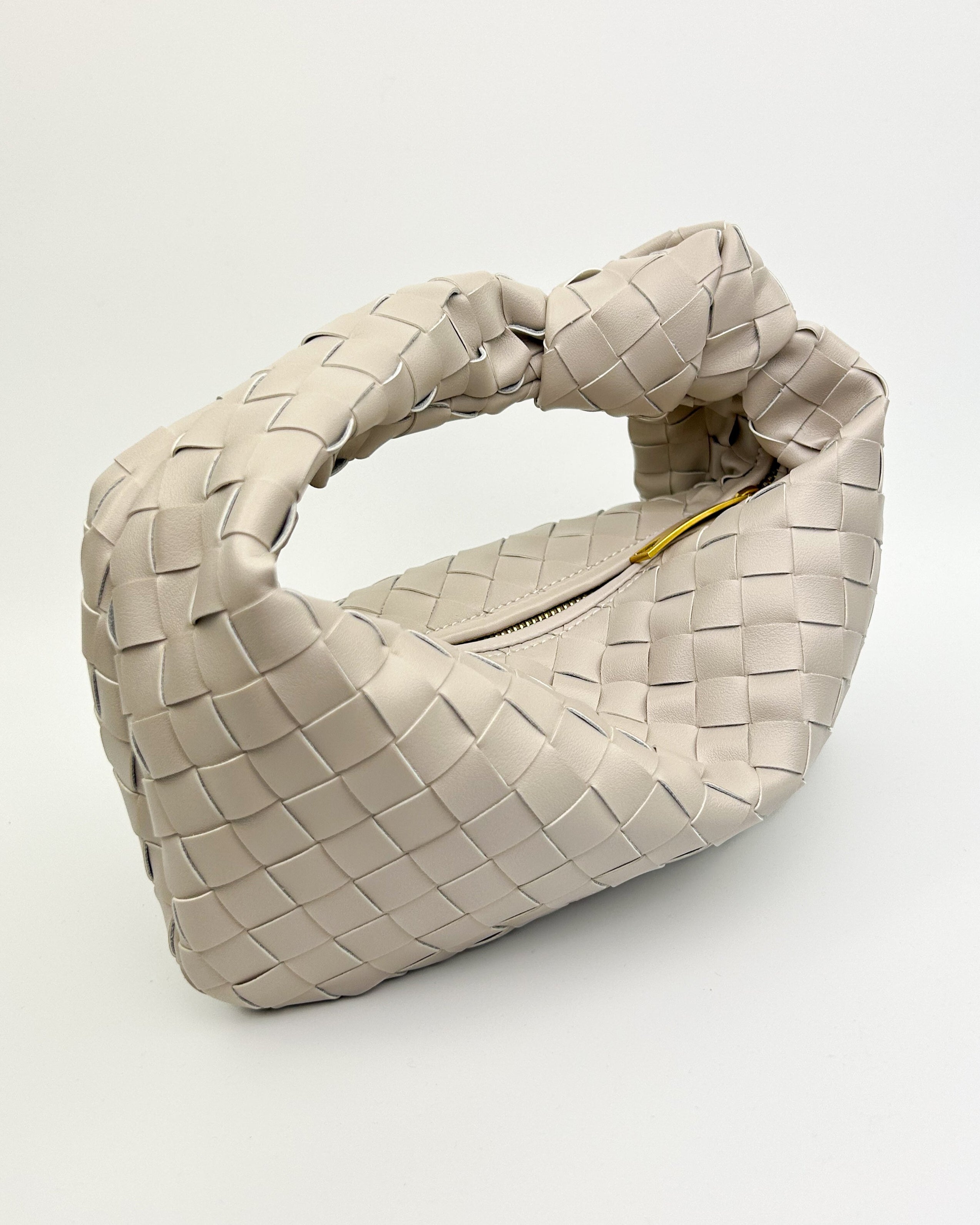 Close-up of oyster white woven leather texture and knotted handle, handcrafted from premium Italian calf leather